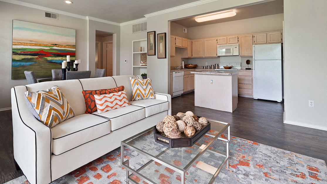 Spacious Living Room with Wood Style Flooring and View of Kitchen with White Appliances, Kitchen Island, Quartz Countertops, and Light Cabinetry